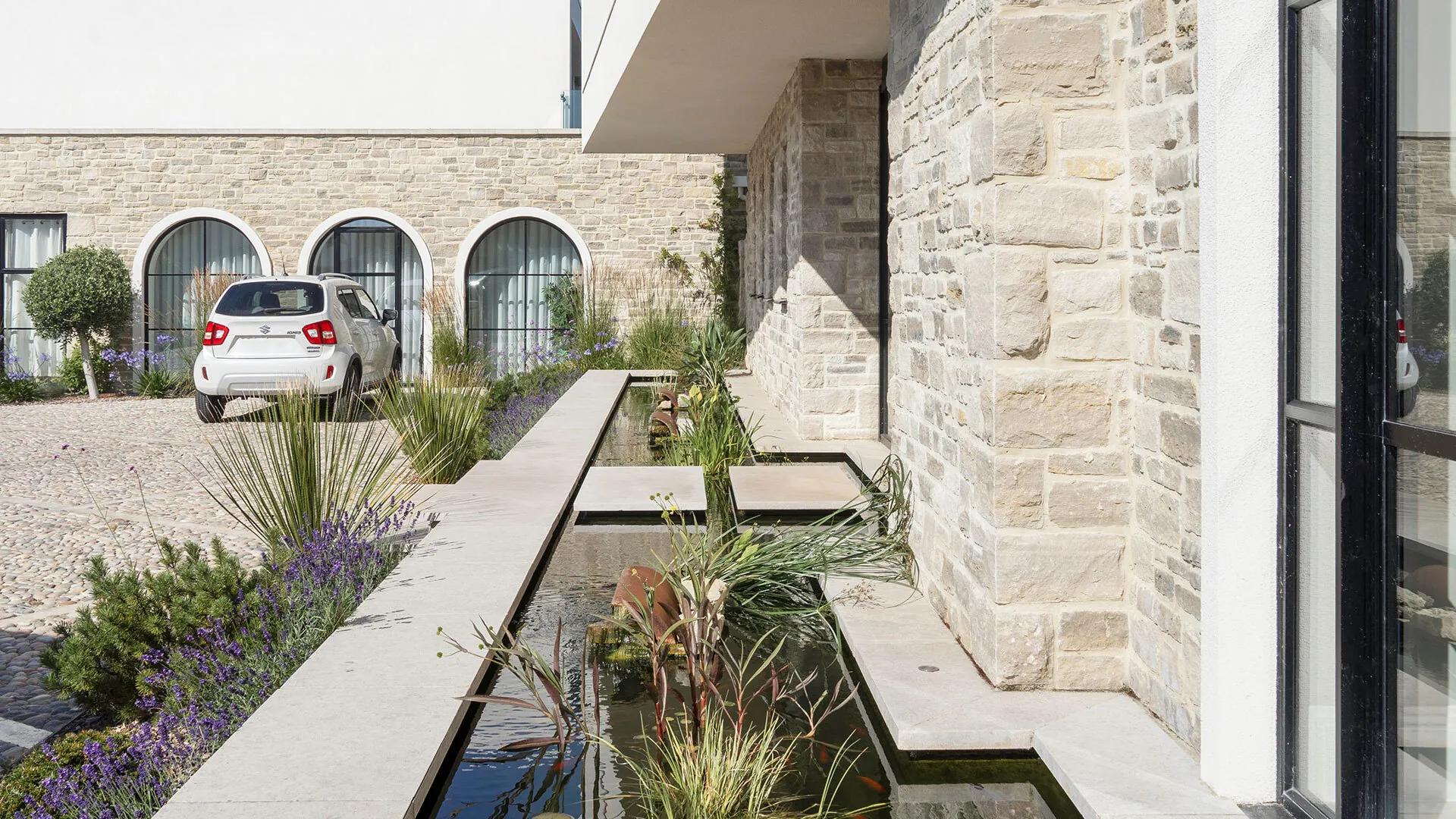 Bespoke Lymington Beige limestone downstand copings on a pond in Canford Cliffs, Poole