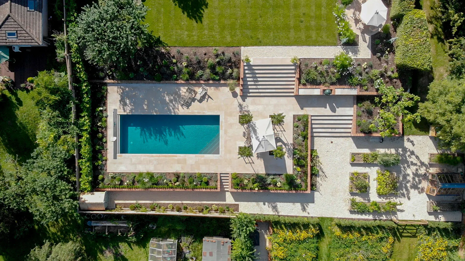 Drone view of a Lymington Beige limestone swimming pool and garden in Winchester